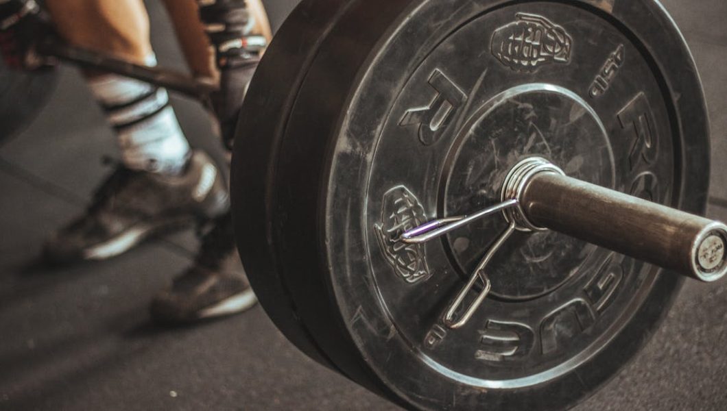 Close-up of a weightlifter's legs and barbell during a workout session.