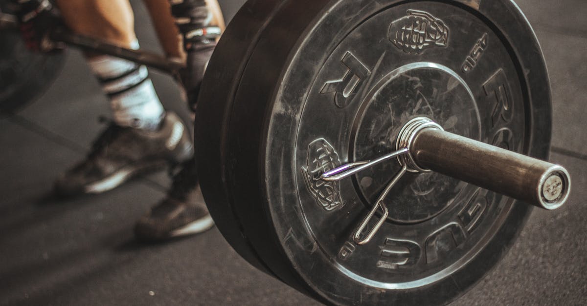 Close-up of a weightlifter's legs and barbell during a workout session.